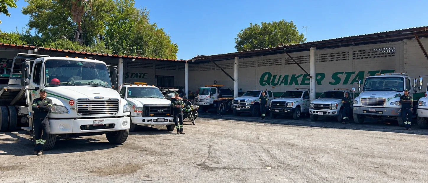 Operadores de Grúas Garza uniformados junto a la flota en la base de Linares