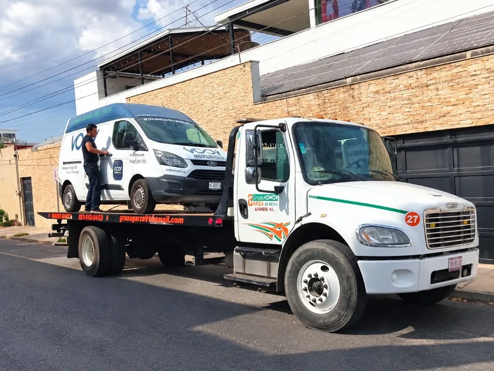 Grúa de plataforma clase B número 27 de Grúas Garza con una camioneta van cargada